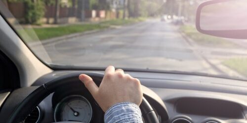 Man driving by looking out the windshield as well as the rear view mirror